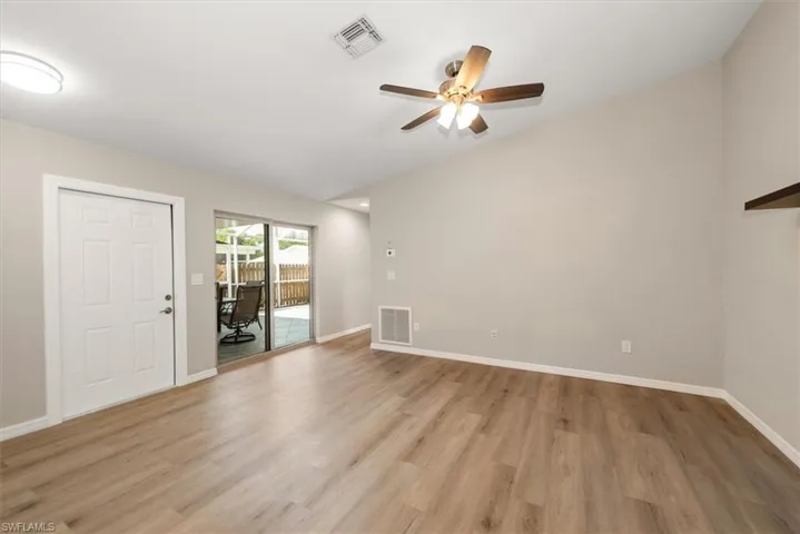 Unfurnished living room with light wood finished floors, ceiling fan, and a desk
