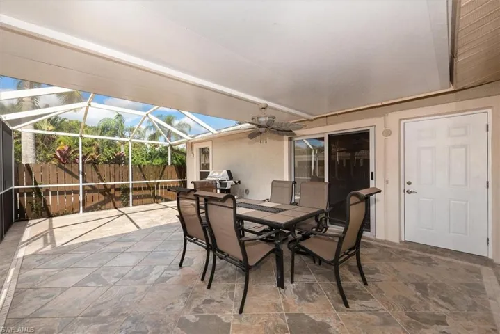 View of patio / terrace with a ceiling fan, a sunroom, outdoor dining space, and glass enclosure