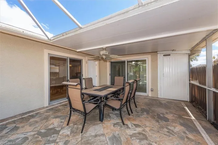 View of patio featuring a sunroom, outdoor dining area, and ceiling fan
