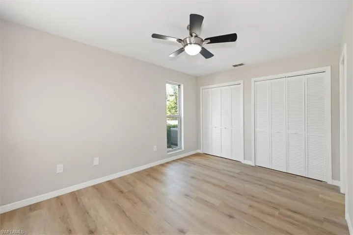 Unfurnished bedroom featuring two closets, light wood finished floors, and ceiling fan