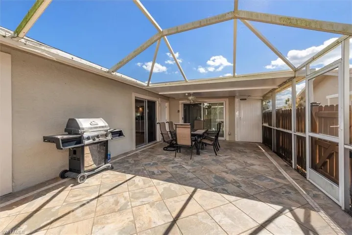 Sunroom / solarium with outdoor dining area, a ceiling fan, and a patio