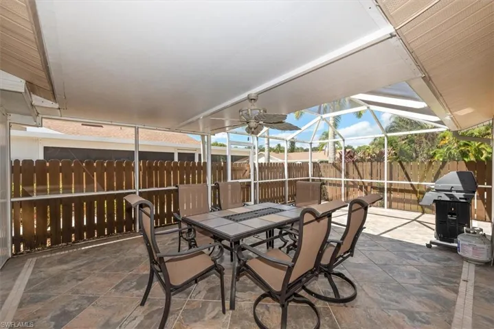 View of patio / terrace featuring outdoor dining space, a sunroom, grilling area, glass enclosure, and ceiling fan