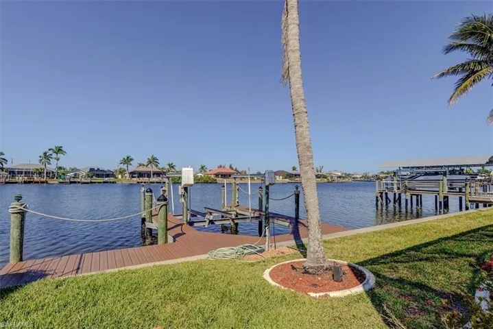 Dock area featuring a lawn, a water view, and boat lift
