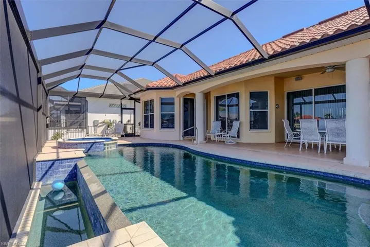 View of pool featuring outdoor dining space, a patio area, ceiling fan, a lanai, and a pool with connected hot tub
