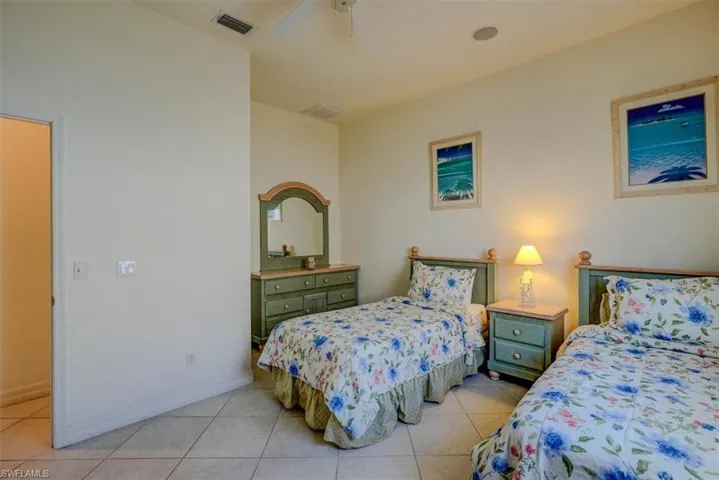 Bedroom featuring baseboards, visible vents, ceiling fan, and light tile patterned flooring