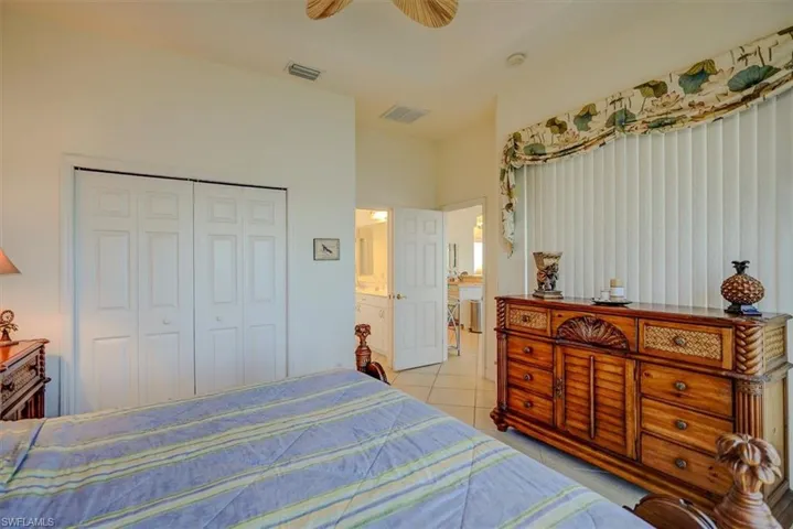 Bedroom with a ceiling fan, a closet, visible vents, and light tile patterned floors