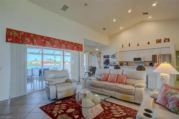 Living area with recessed lighting, visible vents, a ceiling fan, light tile patterned flooring, and high vaulted ceiling