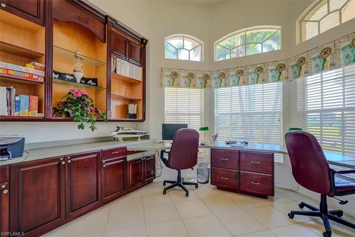 Home office featuring a towering ceiling and light tile patterned floors