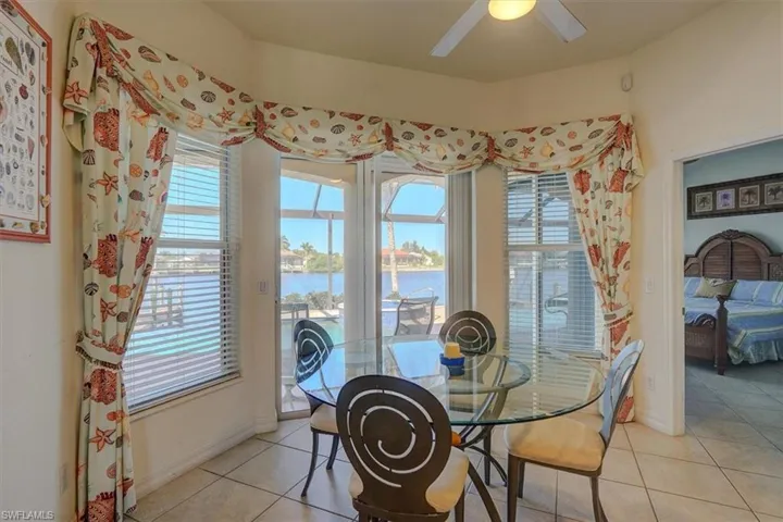 Dining room with a healthy amount of sunlight, light tile patterned flooring, and a water view
