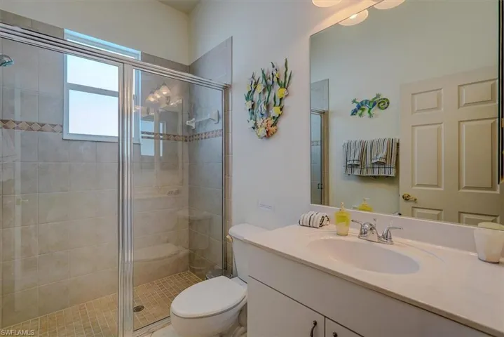 Full bathroom with a stall shower, vanity, and toilet