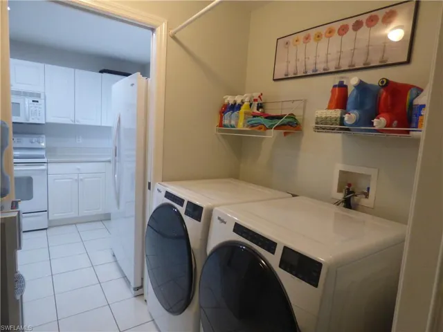 Washroom featuring brand new washer and dryer, light tile flooring, and hookup for a washing machine