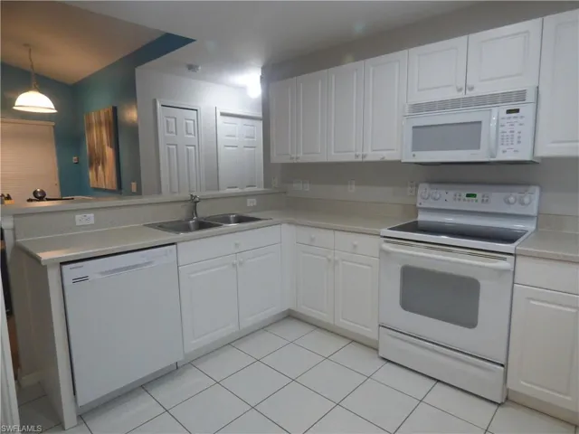 Large Kitchen featuring sink, white cabinetry, white appliances, and light tile floors
