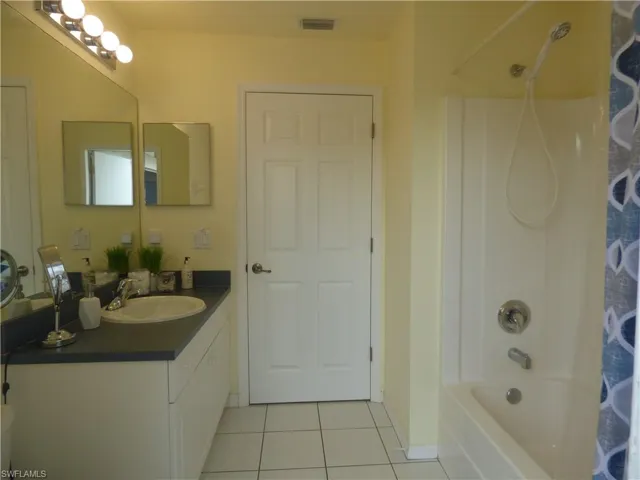 Bathroom featuring tile flooring, vanity, and shower / tub combo