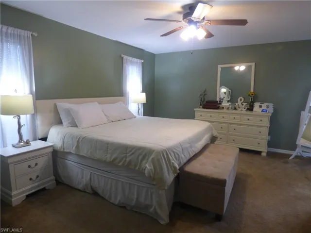 Bedroom featuring ceiling fan, multiple windows and sliders to patio