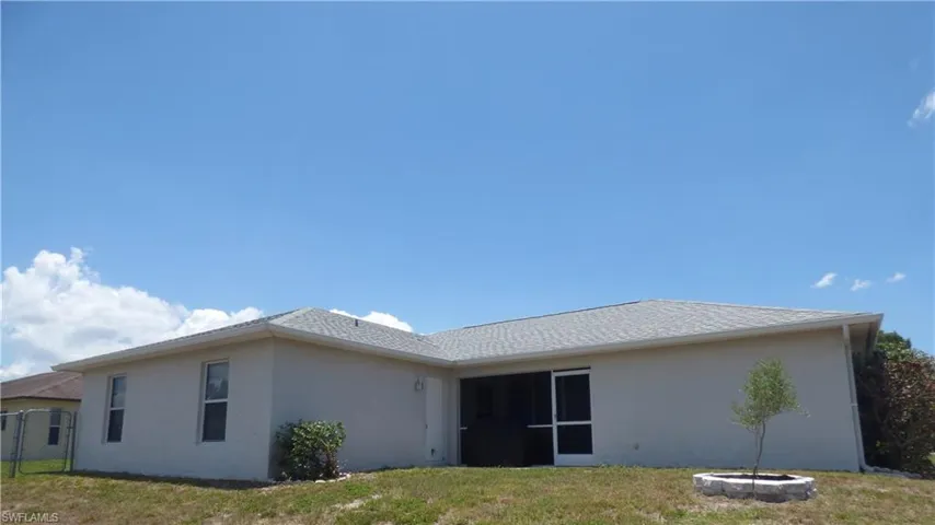 Back of house with a lawn and fenced backyard