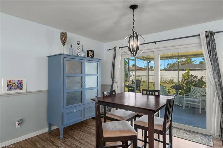 Dining area featuring an inviting chandelier and hardwood / wood-style flooring
