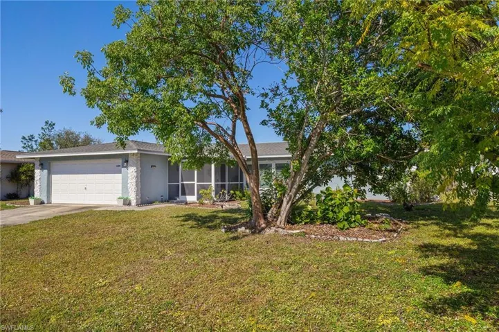 Single story home featuring a garage and a front lawn
