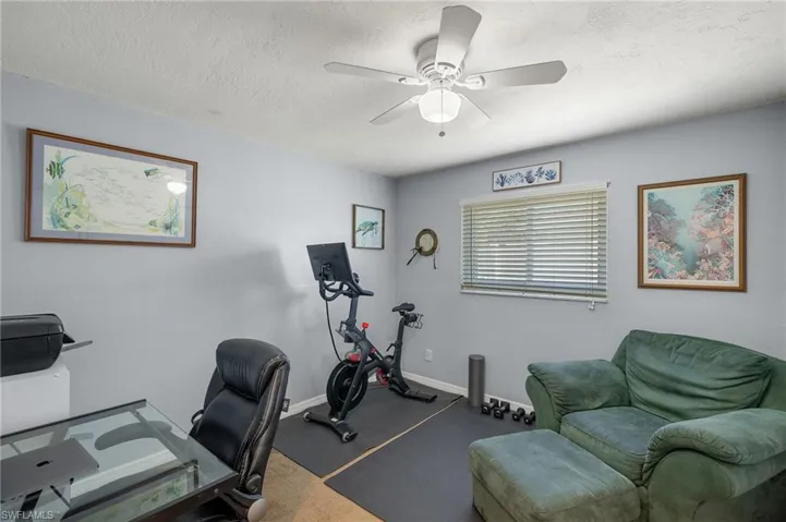 Office area featuring ceiling fan and a textured ceiling