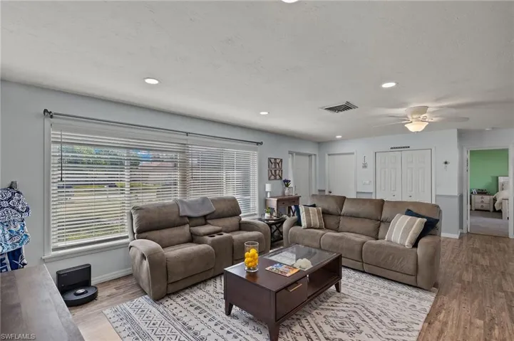Living room featuring ceiling fan, a textured ceiling, and light hardwood / wood-style floors