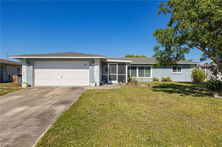 Single story home with a garage and a front lawn