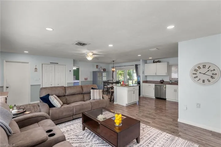 Living room with sink, ceiling fan, and light hardwood / wood-style flooring
