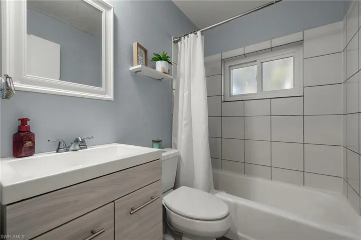 Full bathroom featuring vanity, shower / tub combo with curtain, and toilet