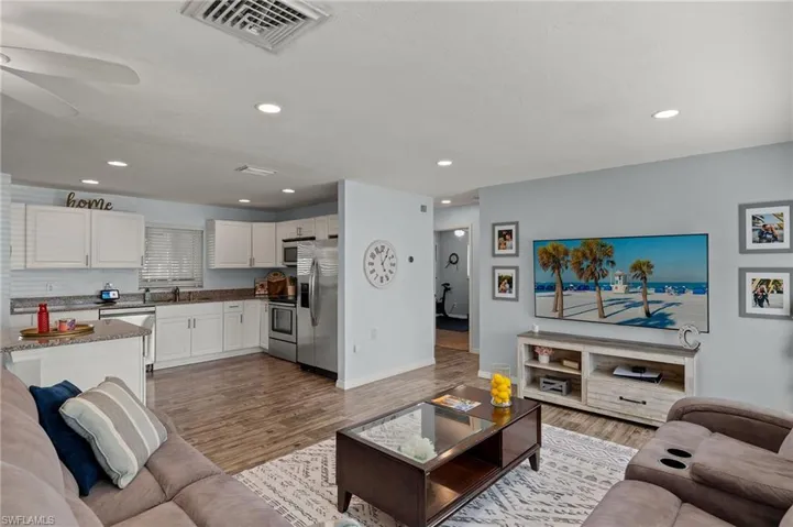 Living room with hardwood / wood-style flooring, ceiling fan, and sink