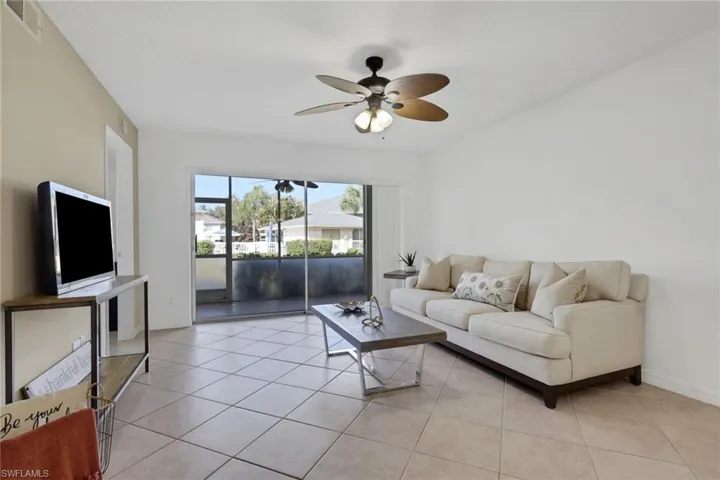 Living area with ceiling fan and light tile patterned flooring
