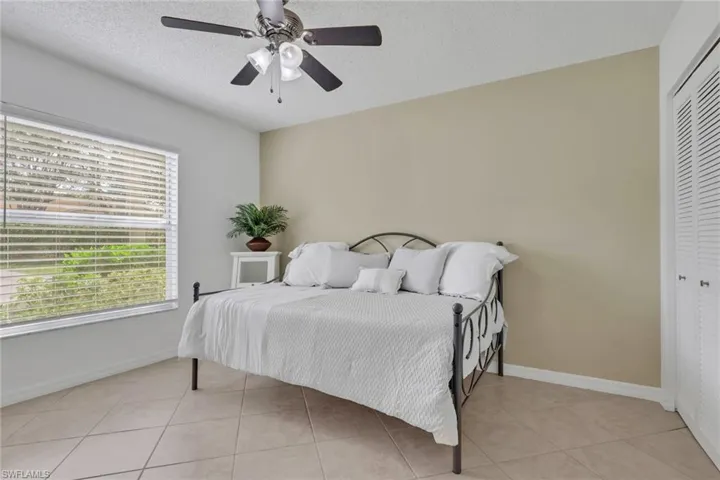 Guest Bedroom featuring a textured ceiling, a ceiling fan, a closet, and light tile patterned flooring