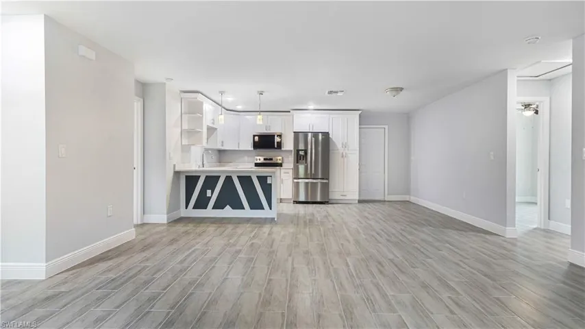 Unfurnished living room with ceiling fan and light hardwood/wood-style floors