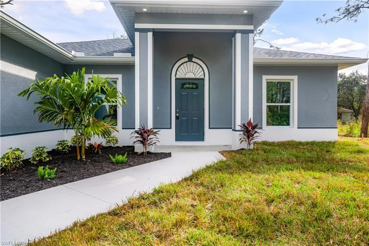 Doorway to property featuring a lawn