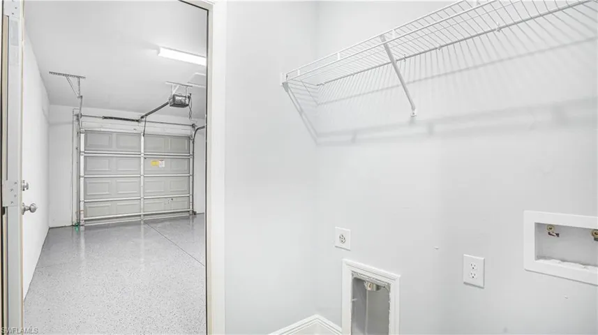 Laundry room with view to garage with epoxy floor