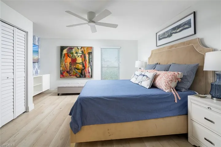 Bedroom with a closet, light hardwood / wood-style floors, multiple windows, and ceiling fan