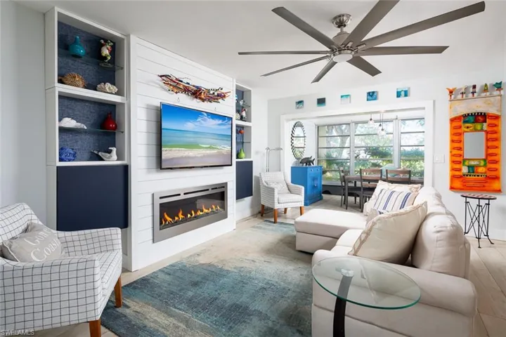 Living room with ceiling fan, built in features, and light hardwood / wood-style flooring