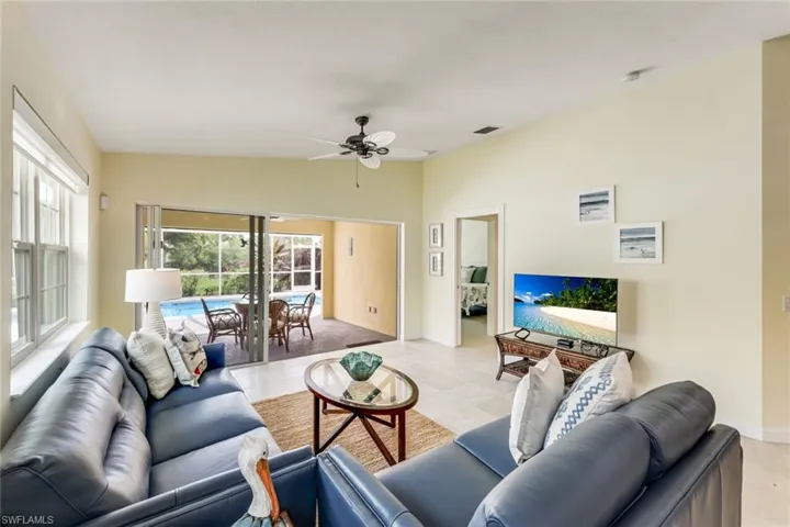 Open-concept living space featuring light-toned tile flooring and vaulted ceilings