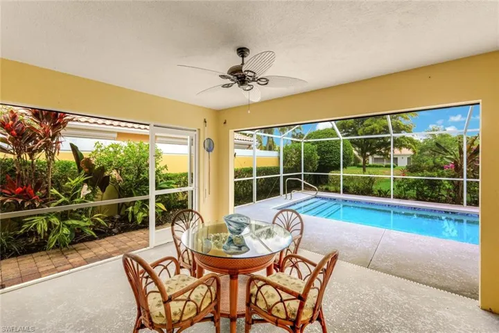 Screened patio featuring an in-ground swimming pool, concrete decking, and lush landscaping