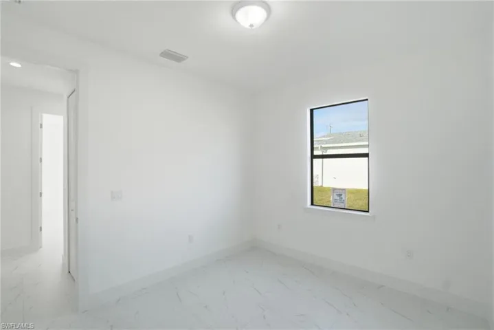 Unfurnished room featuring baseboards and light marble finish floors