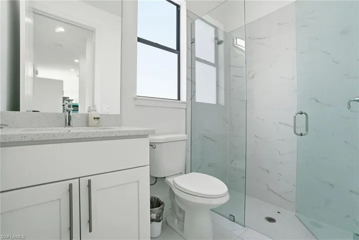 Full bathroom featuring vanity and a marble finish shower
