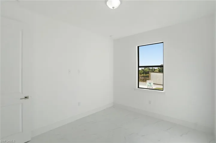 Unfurnished room with baseboards and light marble finish flooring