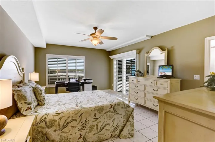 Large Primary Bedroom with bayside views, plantation shutters, and sliders out to 2 balconies.