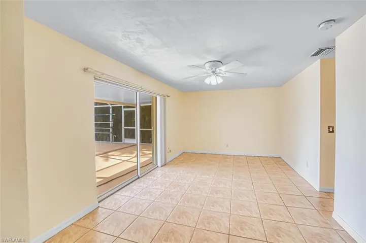 Empty room with a ceiling fan and light tile patterned floors