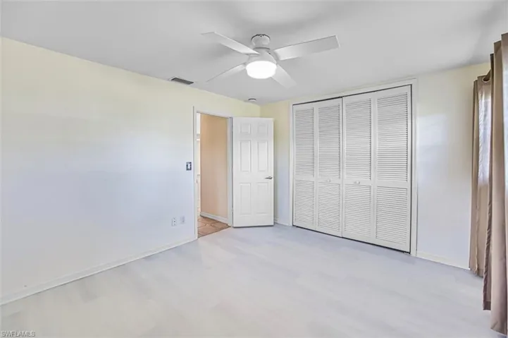 Unfurnished bedroom featuring a closet, light wood-style flooring, and a ceiling fan