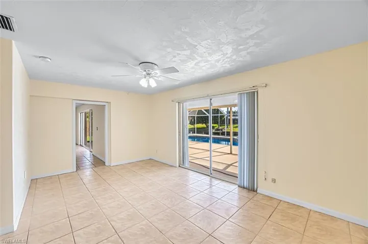 Unfurnished room with light tile patterned floors, a ceiling fan, and a textured ceiling
