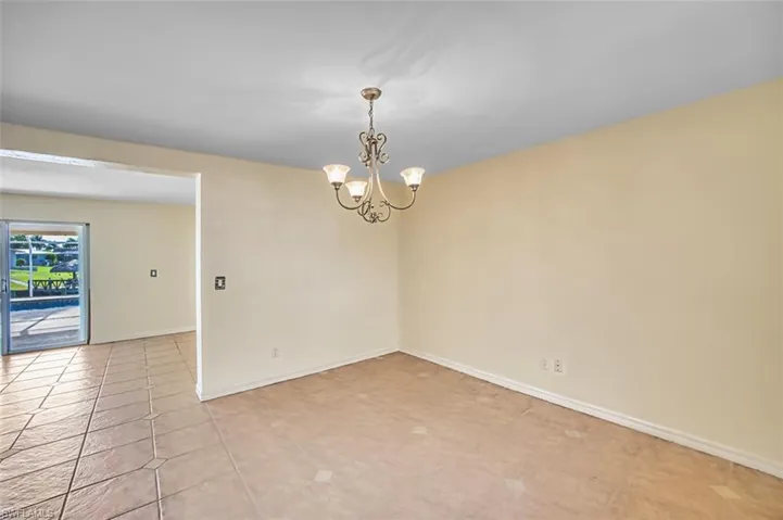 Unfurnished room featuring a chandelier and light tile patterned floors
