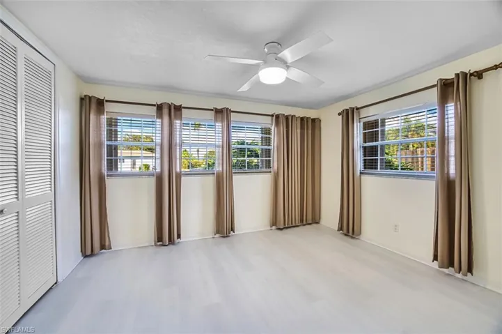 Spare room featuring healthy amount of natural light, light wood-style flooring, and ceiling fan