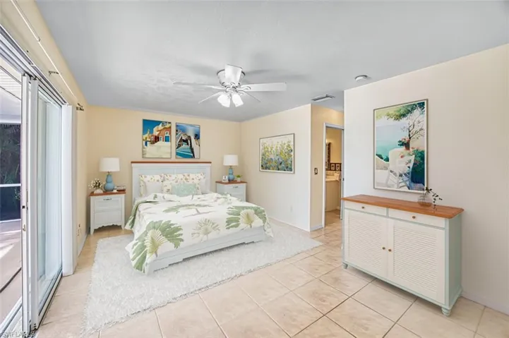 Bedroom featuring light tile patterned floors, access to outside, and a ceiling fan. Virtually Staged.