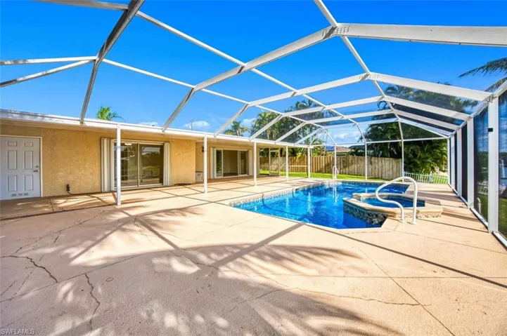View of swimming pool with glass enclosure, a sunroom, a patio, and a pool with connected hot tub