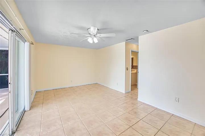 Spare room with ceiling fan and light tile patterned floors