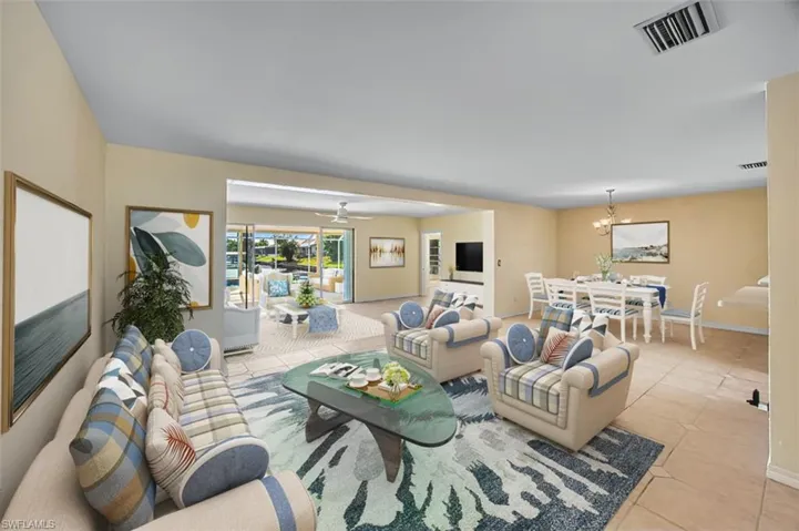 Living room featuring light tile patterned floors, a chandelier, and ceiling fan. Virtually Staged
