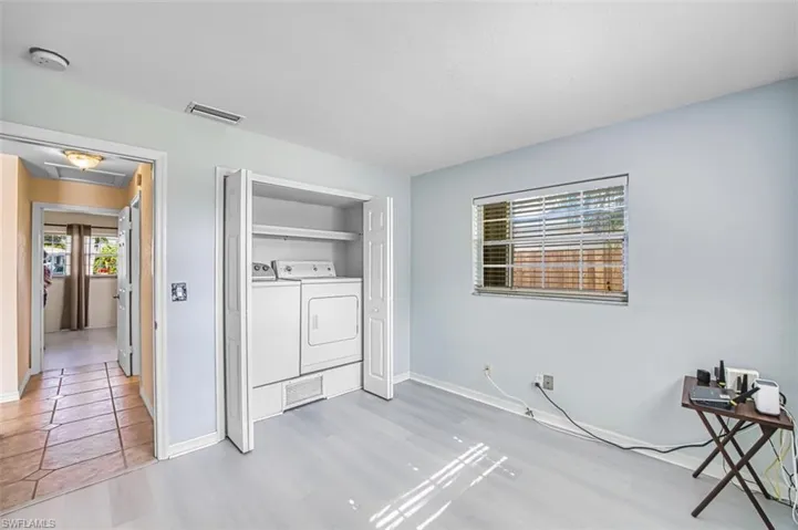 Laundry area brought in from garage, featuring light wood finished floors and washing machine and dryer